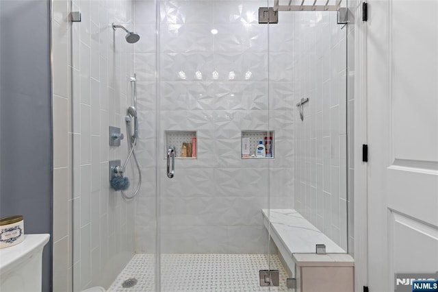 bathroom featuring a stall shower and toilet