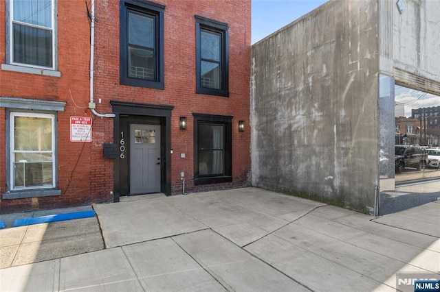 doorway to property with brick siding