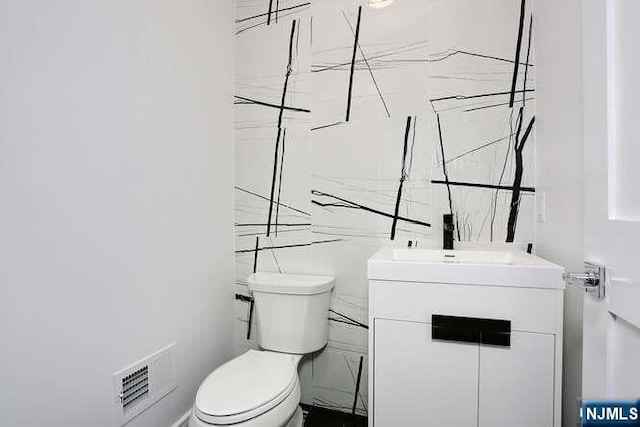 bathroom featuring visible vents, vanity, and toilet