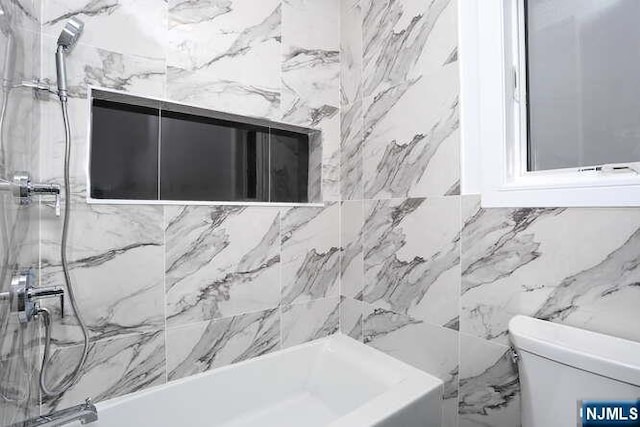 bathroom featuring shower / tub combination and toilet