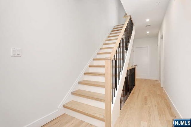 stairs featuring recessed lighting, wood finished floors, and baseboards