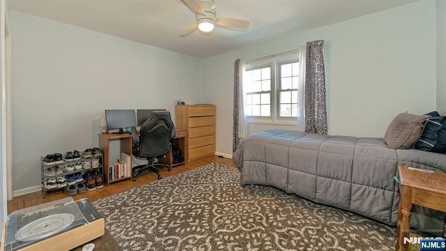 bedroom featuring wood finished floors, baseboards, and ceiling fan