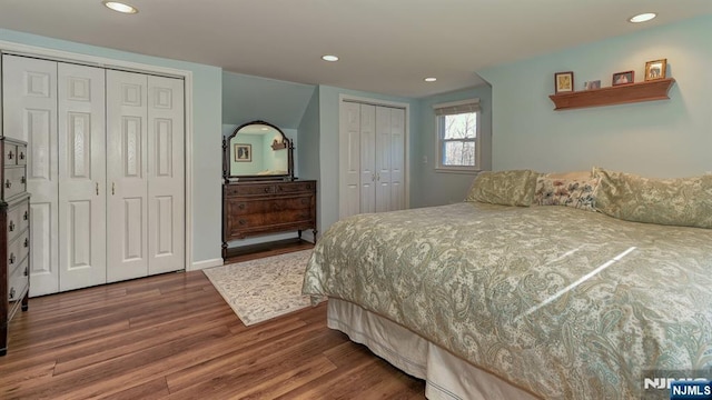 bedroom with recessed lighting, wood finished floors, and two closets