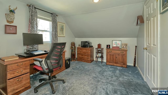 carpeted home office featuring vaulted ceiling and baseboards