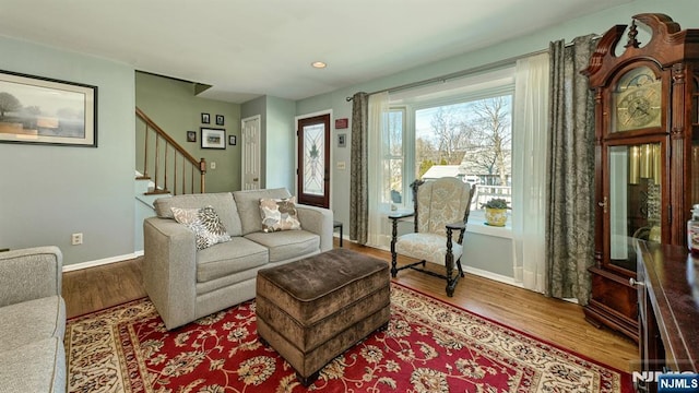 living room featuring stairs, wood finished floors, and baseboards