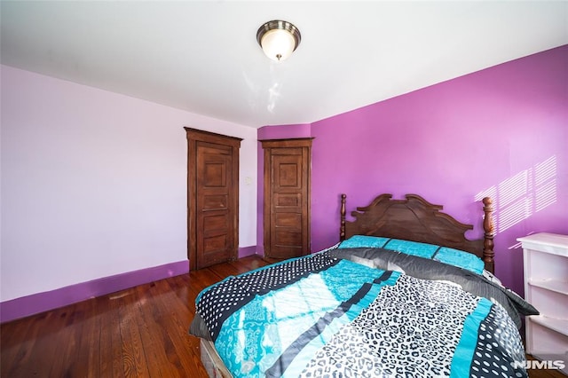 bedroom featuring baseboards and wood finished floors