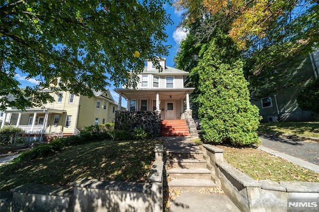 american foursquare style home with covered porch