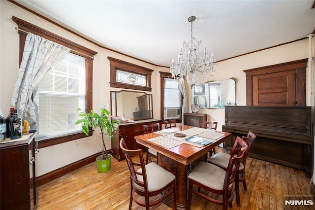 dining area featuring baseboards, light wood-style floors, an inviting chandelier, and crown molding