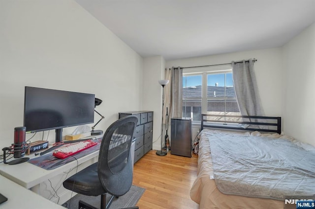 bedroom featuring fridge and wood finished floors