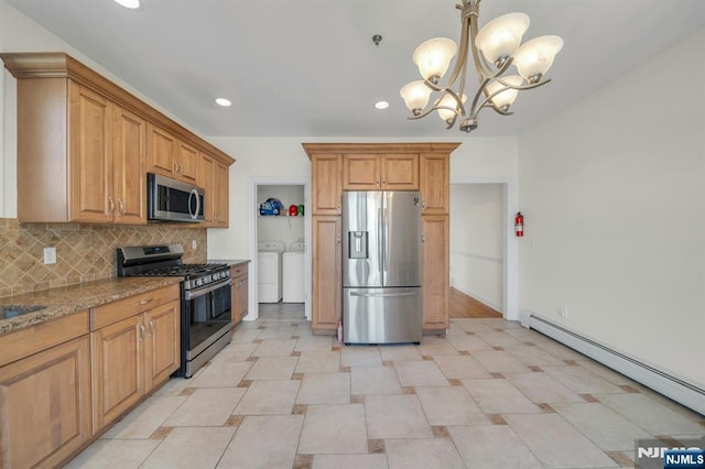 kitchen with light stone counters, independent washer and dryer, baseboard heating, stainless steel appliances, and backsplash