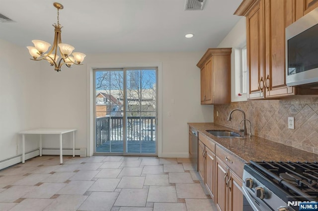 kitchen with visible vents, decorative backsplash, appliances with stainless steel finishes, a sink, and dark stone counters