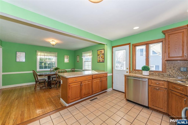 kitchen featuring dishwasher, tasteful backsplash, and brown cabinetry