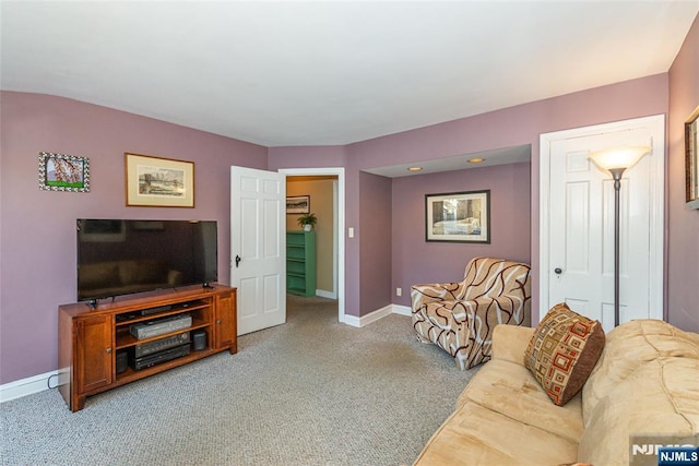 carpeted living area featuring baseboards