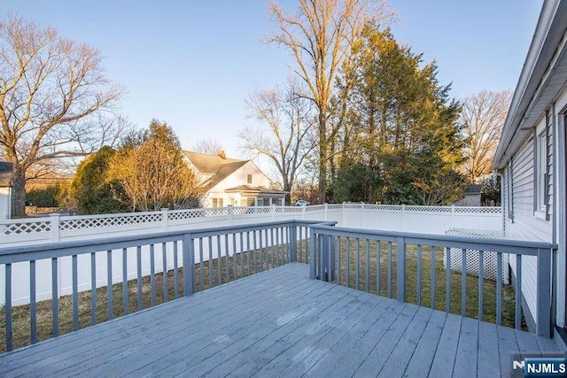 wooden deck with a fenced backyard