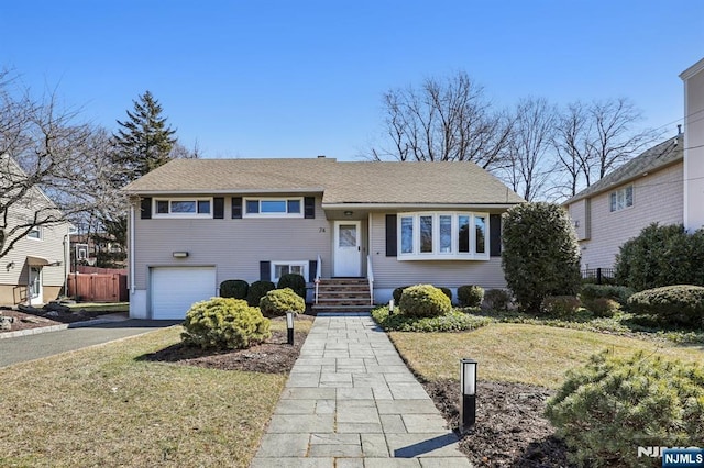 tri-level home featuring driveway, an attached garage, and fence