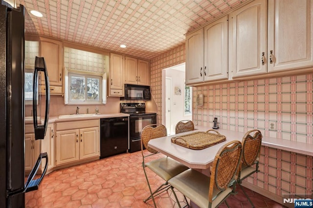 kitchen with a sink, light countertops, backsplash, black appliances, and an ornate ceiling