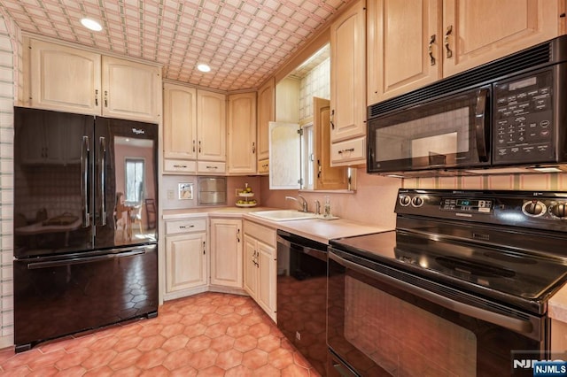 kitchen with black appliances, a sink, light countertops, and recessed lighting