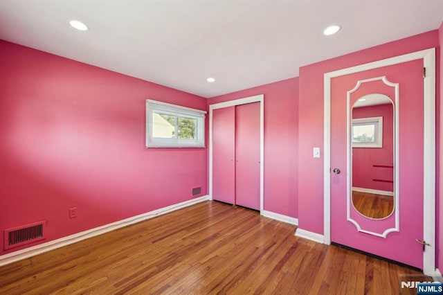 unfurnished bedroom featuring baseboards, visible vents, wood finished floors, a closet, and recessed lighting