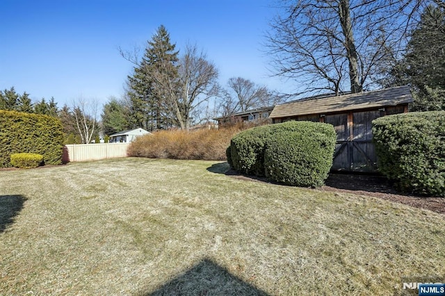 view of yard featuring an outbuilding and fence