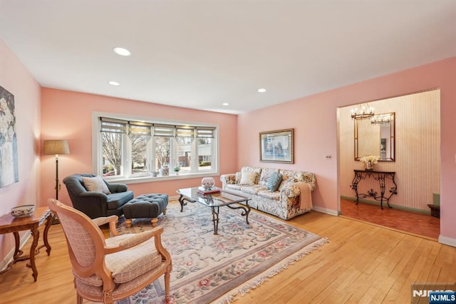 living area featuring a chandelier, recessed lighting, baseboards, and light wood finished floors