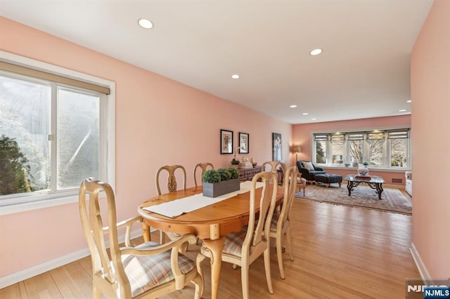 dining space featuring baseboards, wood finished floors, and recessed lighting