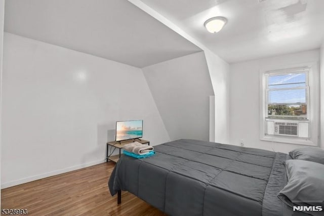 bedroom with baseboards and wood finished floors