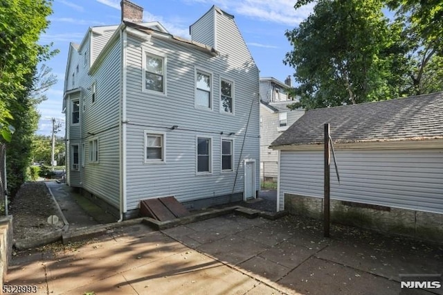 rear view of property featuring a patio and a chimney