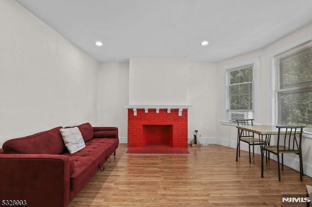 living area featuring a fireplace, plenty of natural light, and wood finished floors