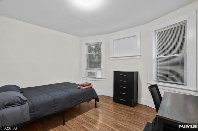 bedroom featuring baseboards and wood finished floors