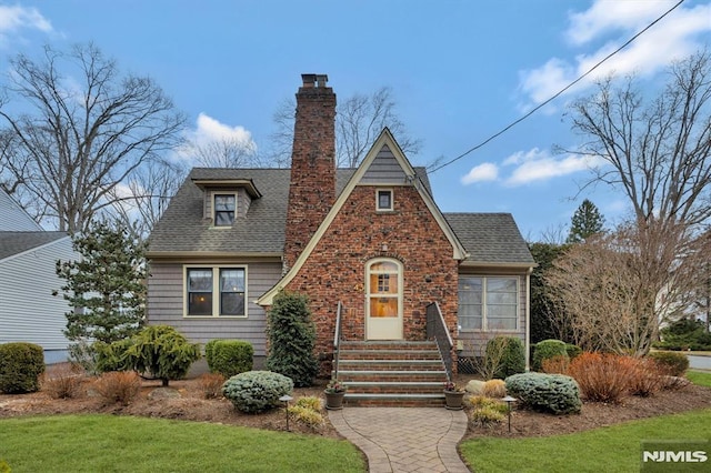 view of front of property with a shingled roof and a chimney