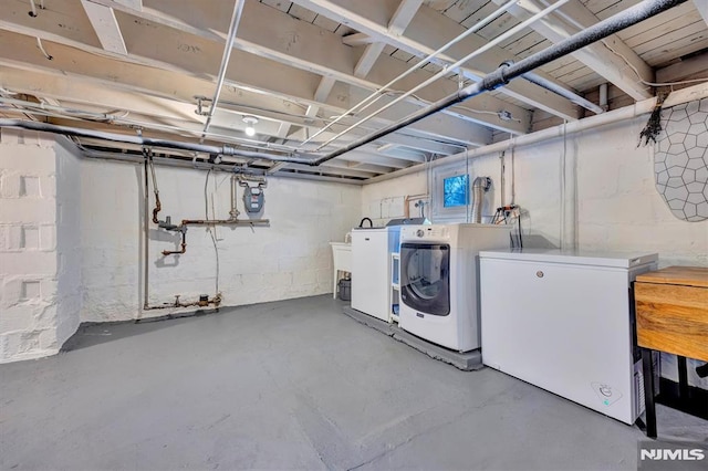 unfinished basement with washer and clothes dryer and fridge