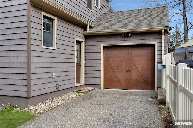 exterior space featuring aphalt driveway and fence