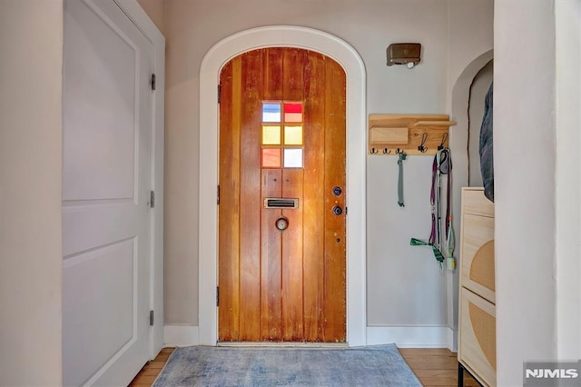 interior space featuring arched walkways and wood finished floors