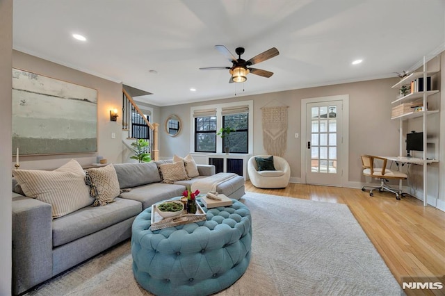 living room featuring baseboards, ornamental molding, wood finished floors, and recessed lighting