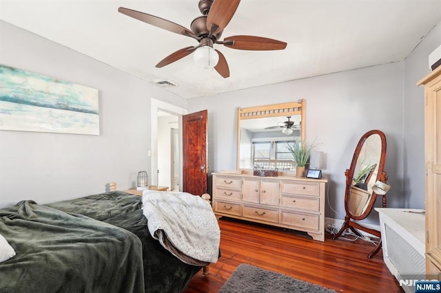 bedroom with dark wood-style flooring, visible vents, and a ceiling fan