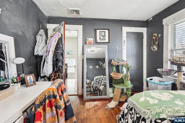 bedroom featuring visible vents, multiple windows, and wood finished floors