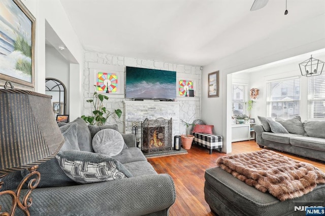 living area featuring a stone fireplace and wood finished floors