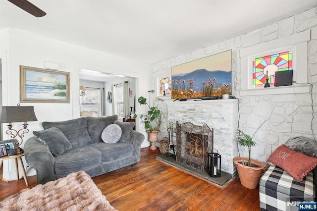 living area featuring a lit fireplace and wood finished floors