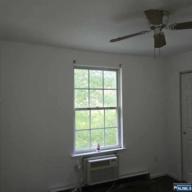 spare room with a wealth of natural light, ceiling fan, baseboards, and a wall mounted AC