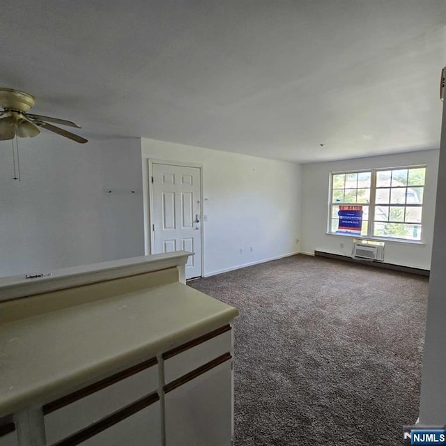 spare room with ceiling fan, dark carpet, baseboards, and a wall mounted AC