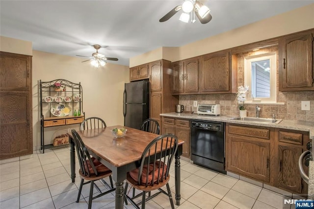 kitchen featuring light tile patterned floors, a sink, light countertops, black appliances, and tasteful backsplash