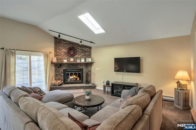 living area with lofted ceiling with skylight, rail lighting, carpet floors, a fireplace, and a baseboard heating unit