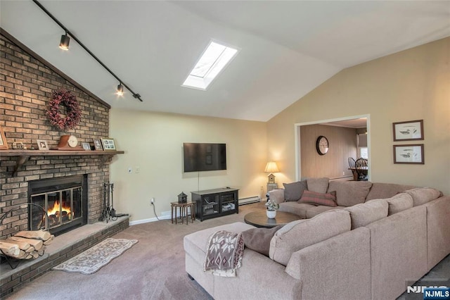 living room with carpet floors, a baseboard radiator, rail lighting, lofted ceiling with skylight, and a brick fireplace