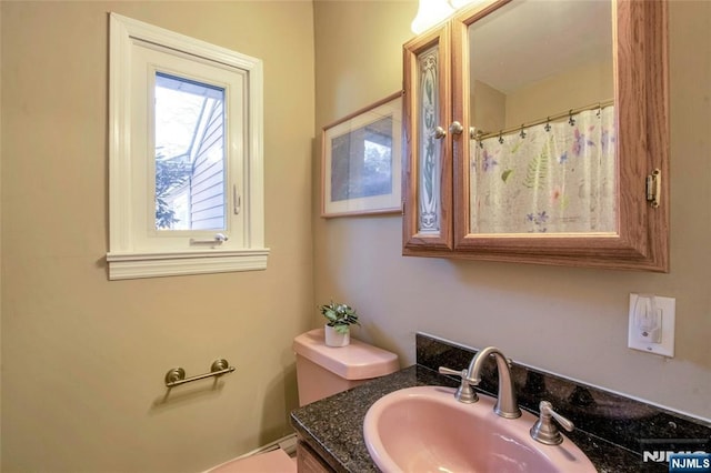 full bathroom with a shower with shower curtain, vanity, and toilet