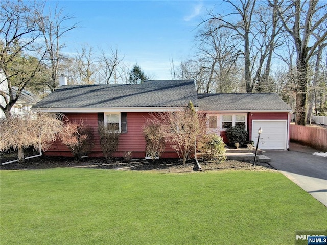 view of front of home featuring aphalt driveway, a front yard, a chimney, and an attached garage