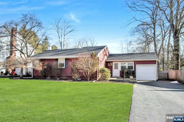 view of front of home with aphalt driveway, a front yard, fence, and an attached garage