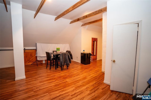 dining area with vaulted ceiling with beams, baseboards, and wood finished floors