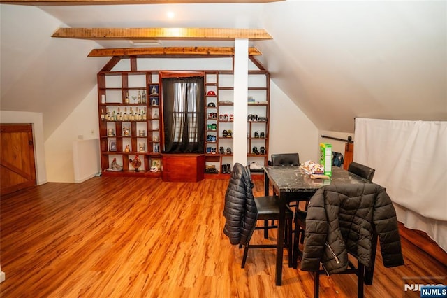 dining room with lofted ceiling with beams and wood finished floors