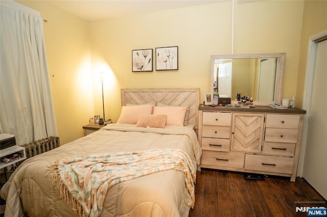 bedroom featuring dark wood-style floors and radiator heating unit