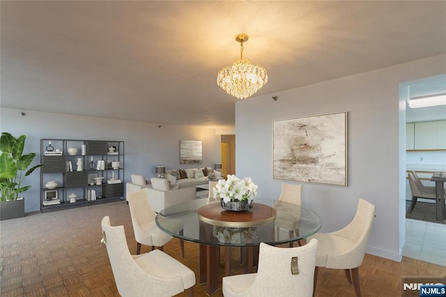 dining room with a chandelier and baseboards